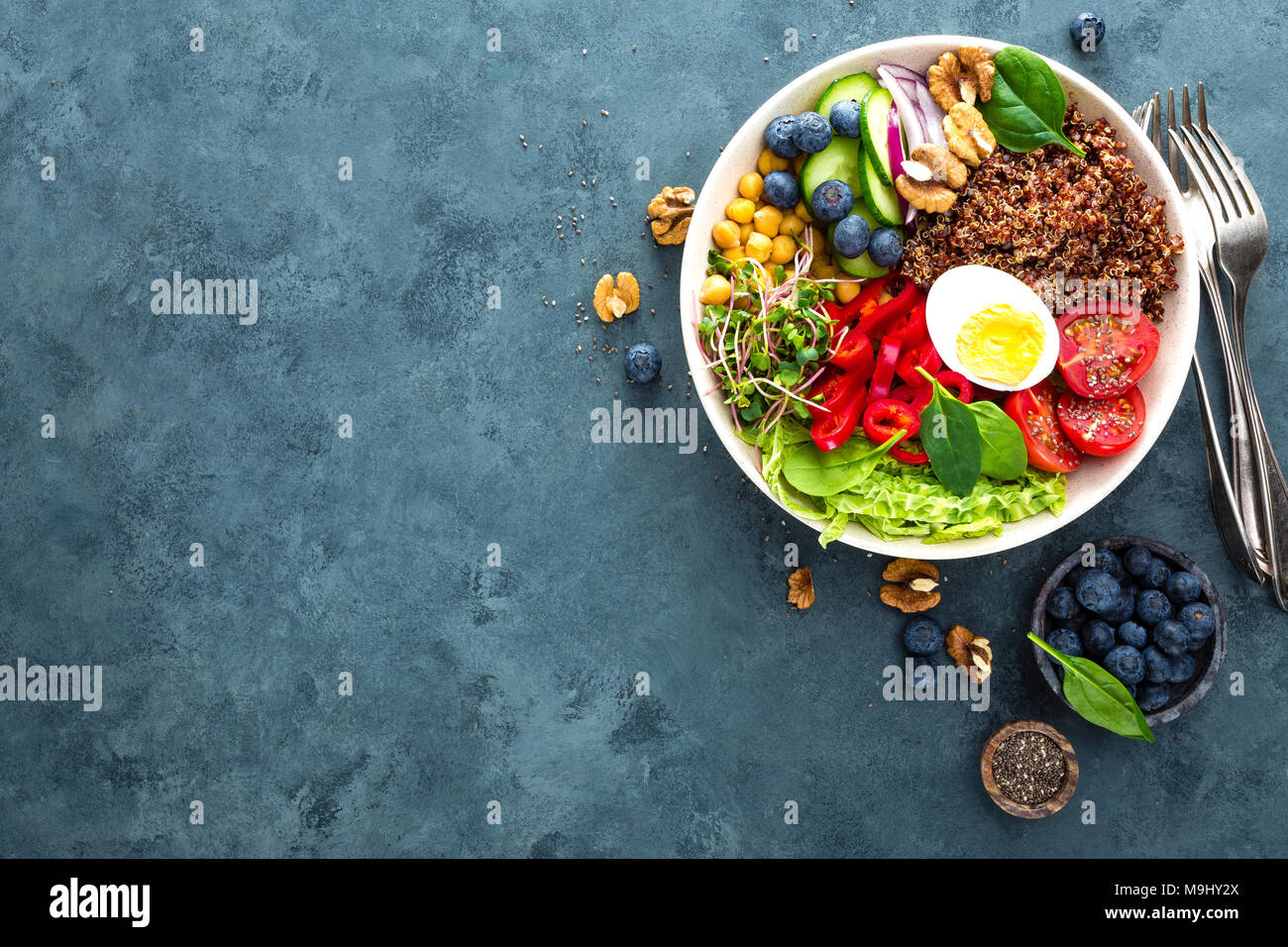 Ciotola di Buddha cena con uova sode, ceci, pomodoro fresco, peperoni, cetrioli, cavolo verza, cipolla rossa, verde i germogli di foglie di spinaci, mirtillo Foto Stock