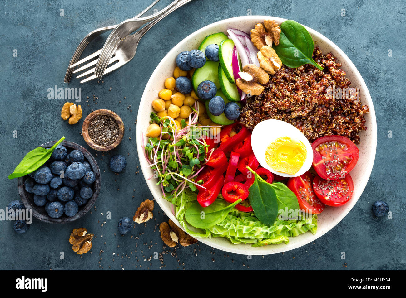 Ciotola di Buddha cena con uova sode, ceci, pomodoro fresco, peperoni, cetrioli, cavolo verza, cipolla rossa, verde i germogli di foglie di spinaci, mirtillo Foto Stock