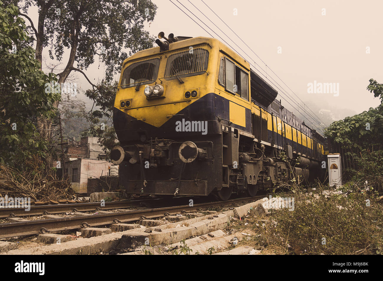 Il trenino giallo va per ferrovia nel deserto. Treno indiano-il treno locale. Provincia indiana, villaggio Foto Stock