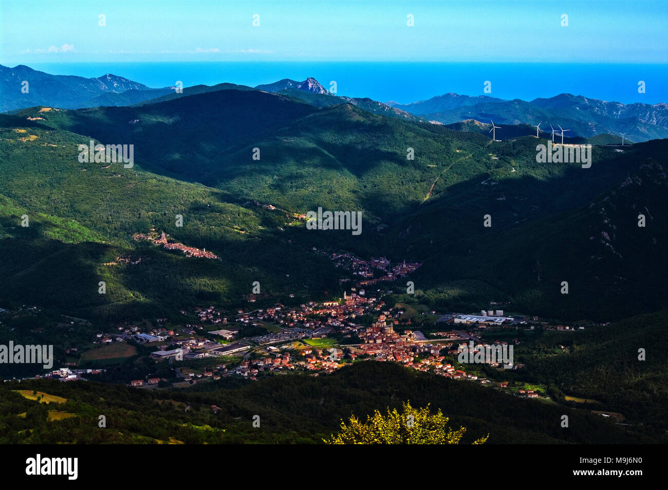 Il bacino di Garessio con, sulla sinistra Valsorda santuario, a destra il parco eolico di San Bernardo e sullo sfondo il mare ligure. Foto Stock