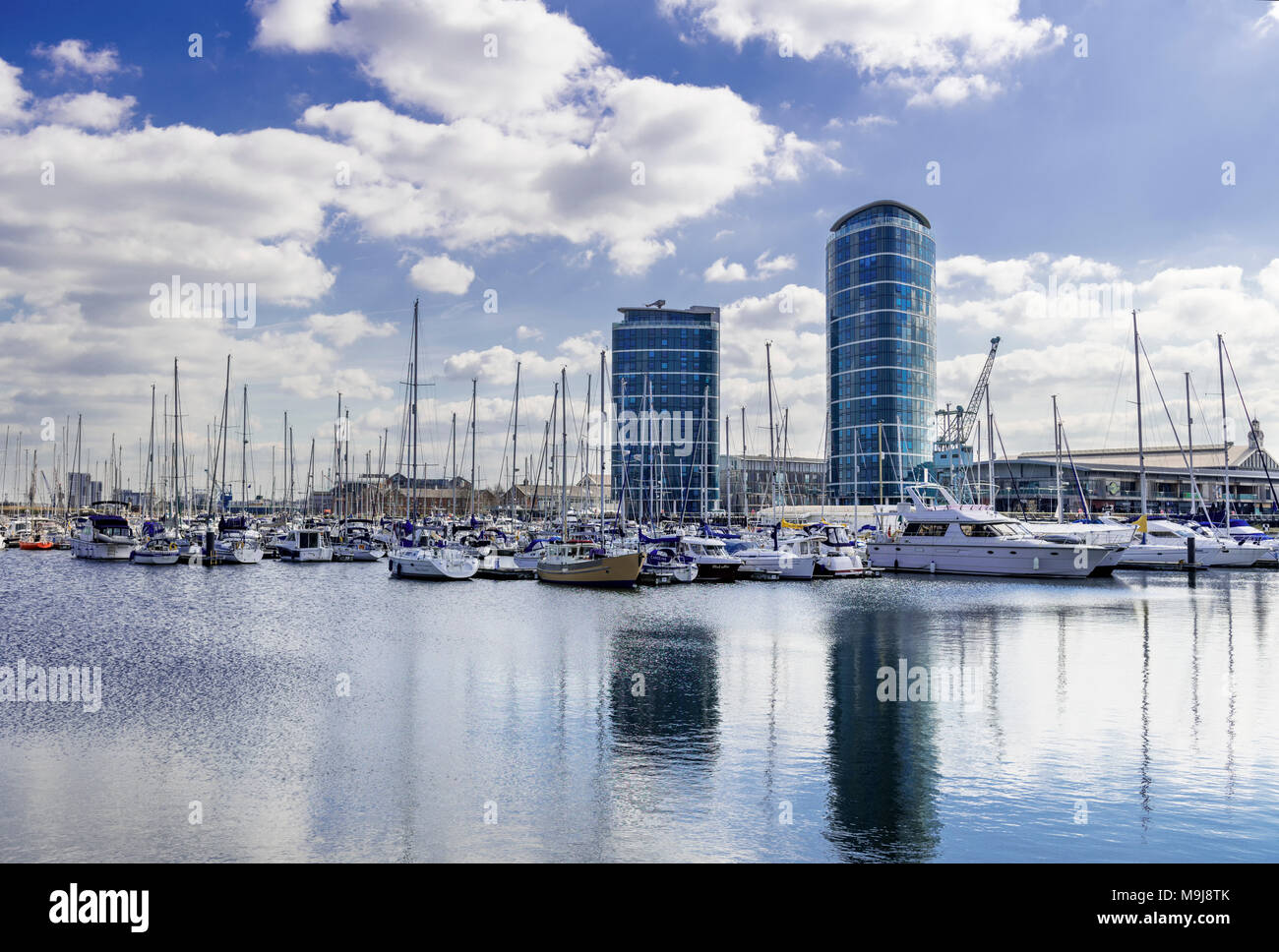 Barche e yacht ormeggiati a Chatham maritime marina nel Kent con 2 edifici alti che si affaccia sulla marina Foto Stock
