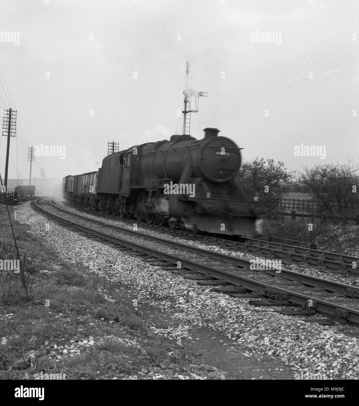 Degli anni Cinquanta, storico, una locomotiva a vapore con carrelli su un binario ferroviario, Inghilterra, Regno Unito. Foto Stock
