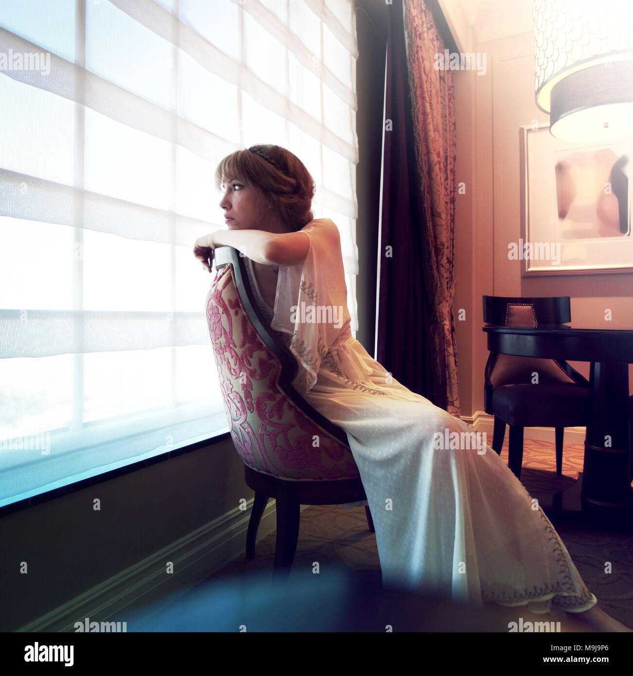 Donna seduta in una stanza Foto Stock
