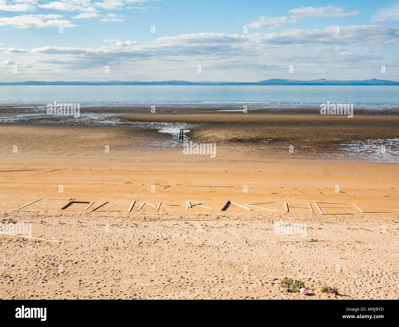 Aberlady Nature Reserve, Aberlady, East Lothian, Scozia, Regno Unito, 26 marzo 2018. Tavole di legno sono lavate in su dopo la fuoriuscita da una nave di carico ‘Frisian Lady’ che ha perso i fasci di legname durante il tempo severo il 2 marzo. Le tavole sono disposte per indicare i nomi Colin e Rachel Foto Stock