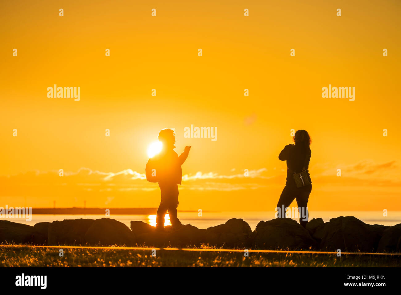 Scattare foto al tramonto sul mare, Saebraut, Reykjavik, Islanda Foto Stock