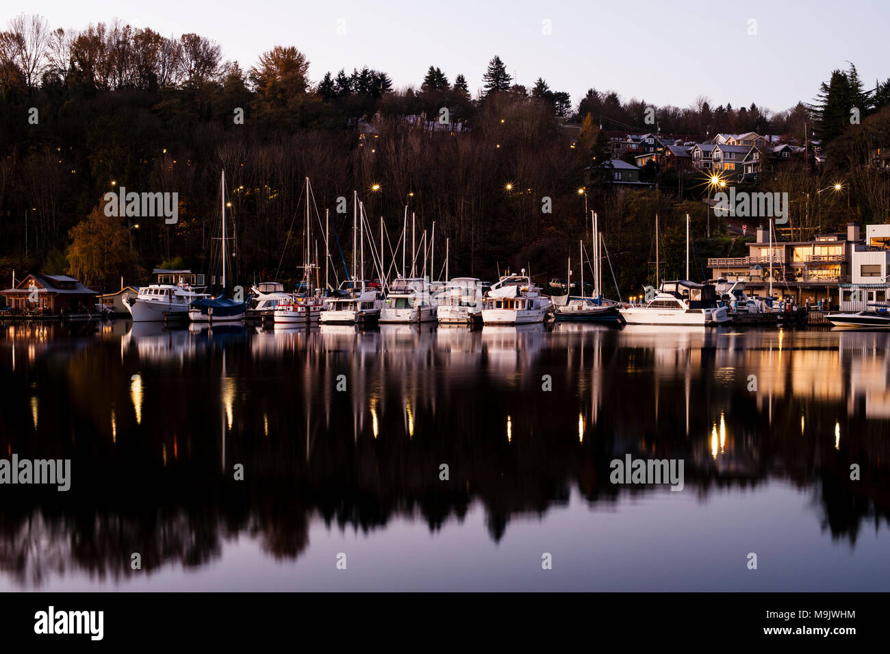 Sunrise il Lago Union con acque calme e barche/houseboat riflessioni di Seattle, nello Stato di Washington STATI UNITI D'AMERICA Foto Stock