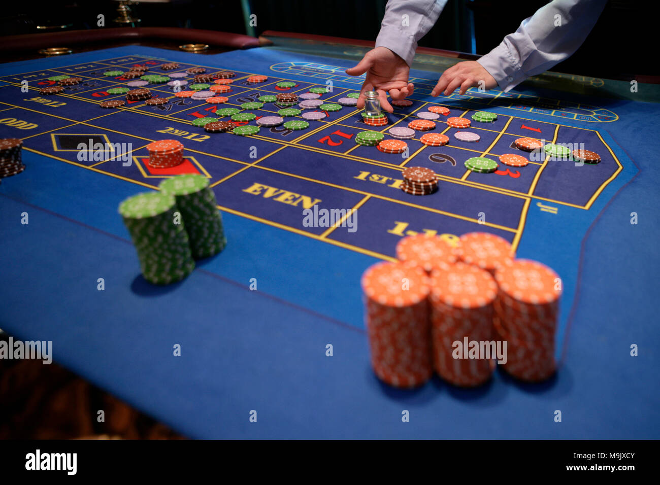 Croupier dietro il tavolo da gioco in un casinò Foto Stock