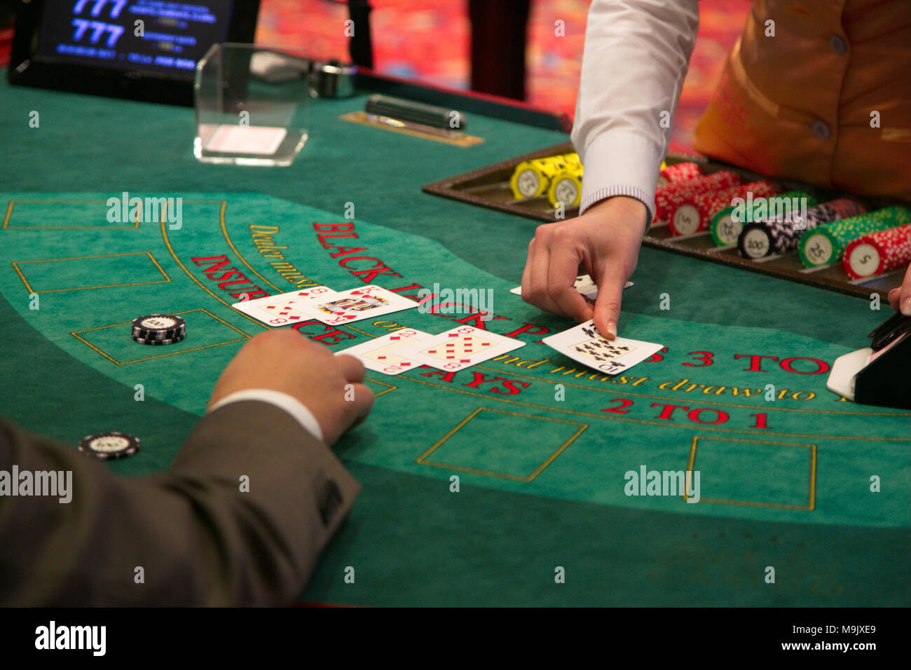Il concessionario mette giù una carta sul tavolo di Blackjack Foto Stock