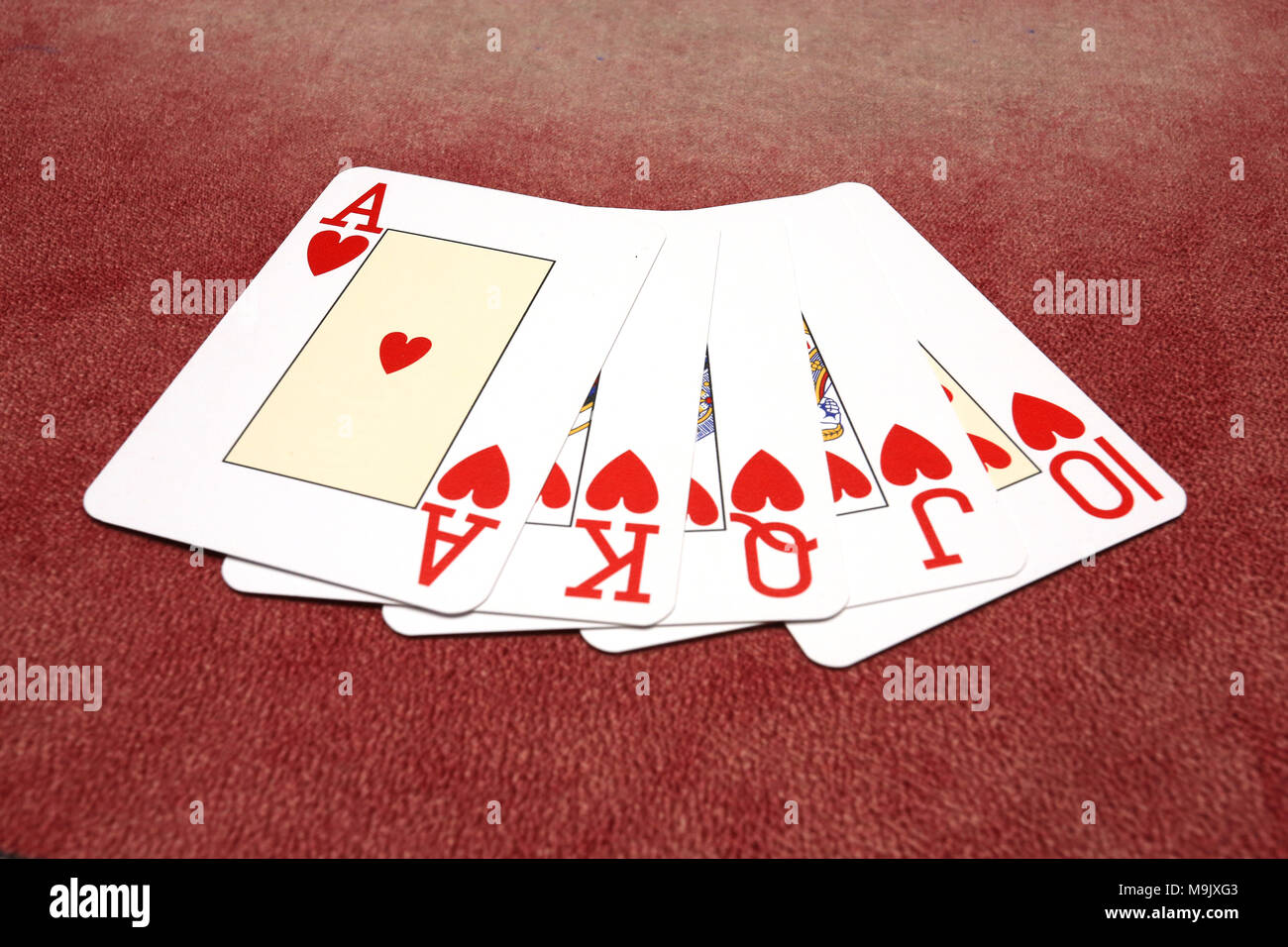 Cuori royal flush isolate su sfondo rosso Foto Stock
