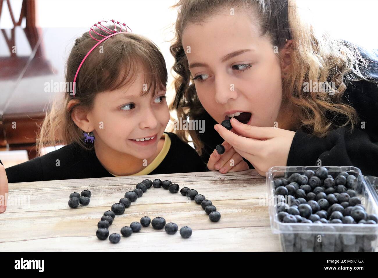 Due sorelle godendo di un fruttato snack insieme Foto Stock