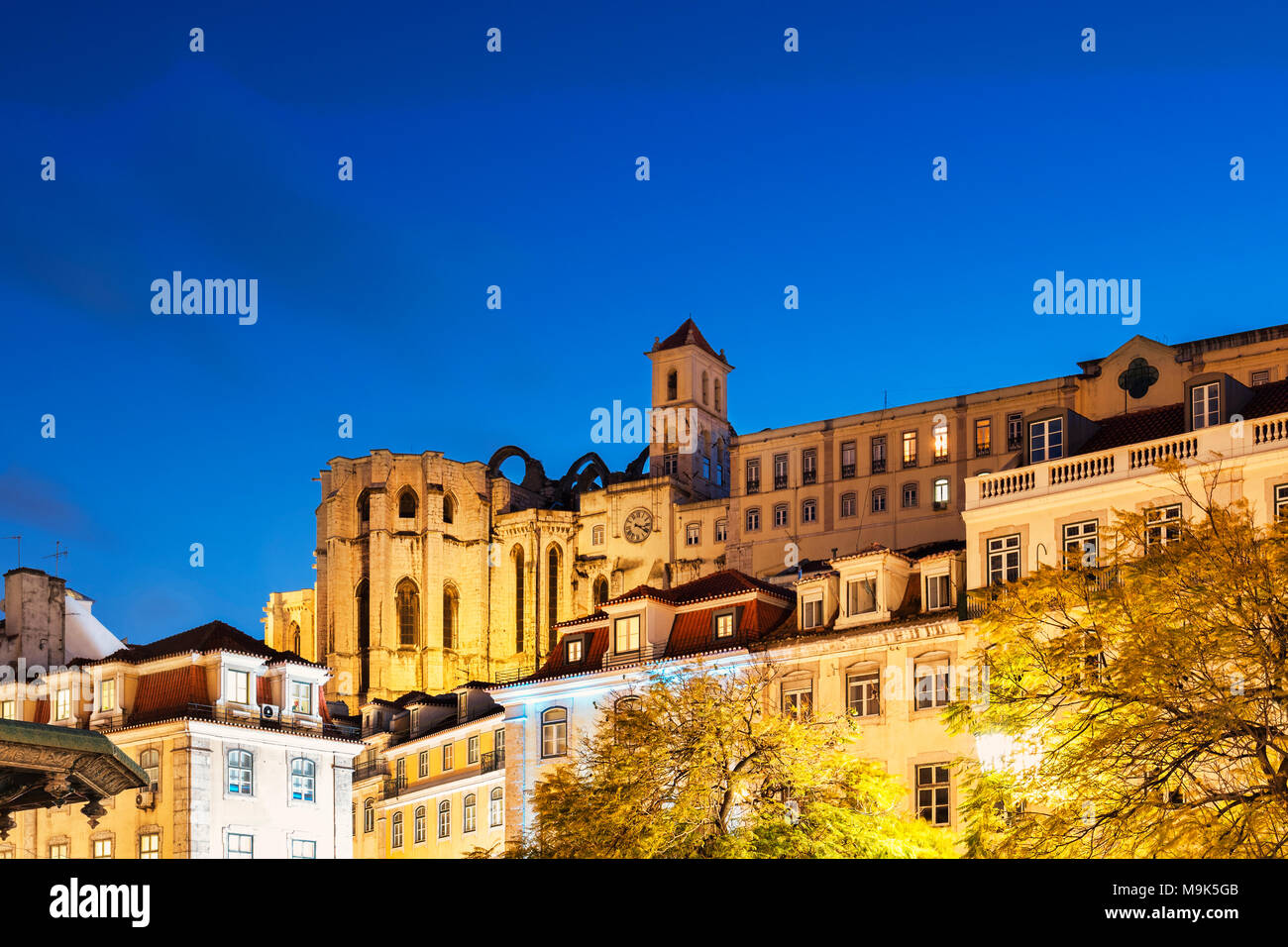 Convento di Nostra Signora del Monte Carmelo accesa al crepuscolo, da piazza Rossio, Lisbona, Portogallo Foto Stock