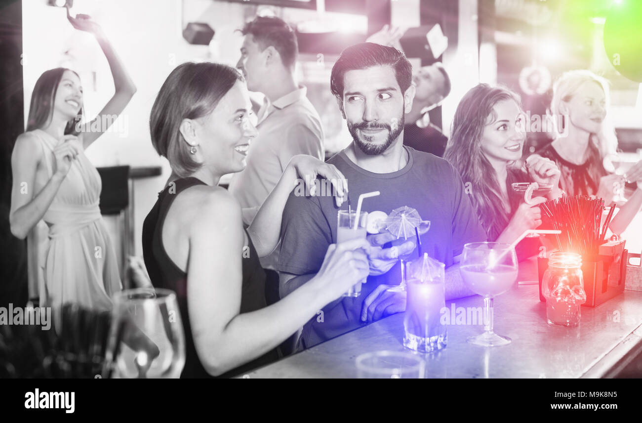 Coppia giovane stanno bevendo cocktail e divertirsi in discoteca Foto Stock