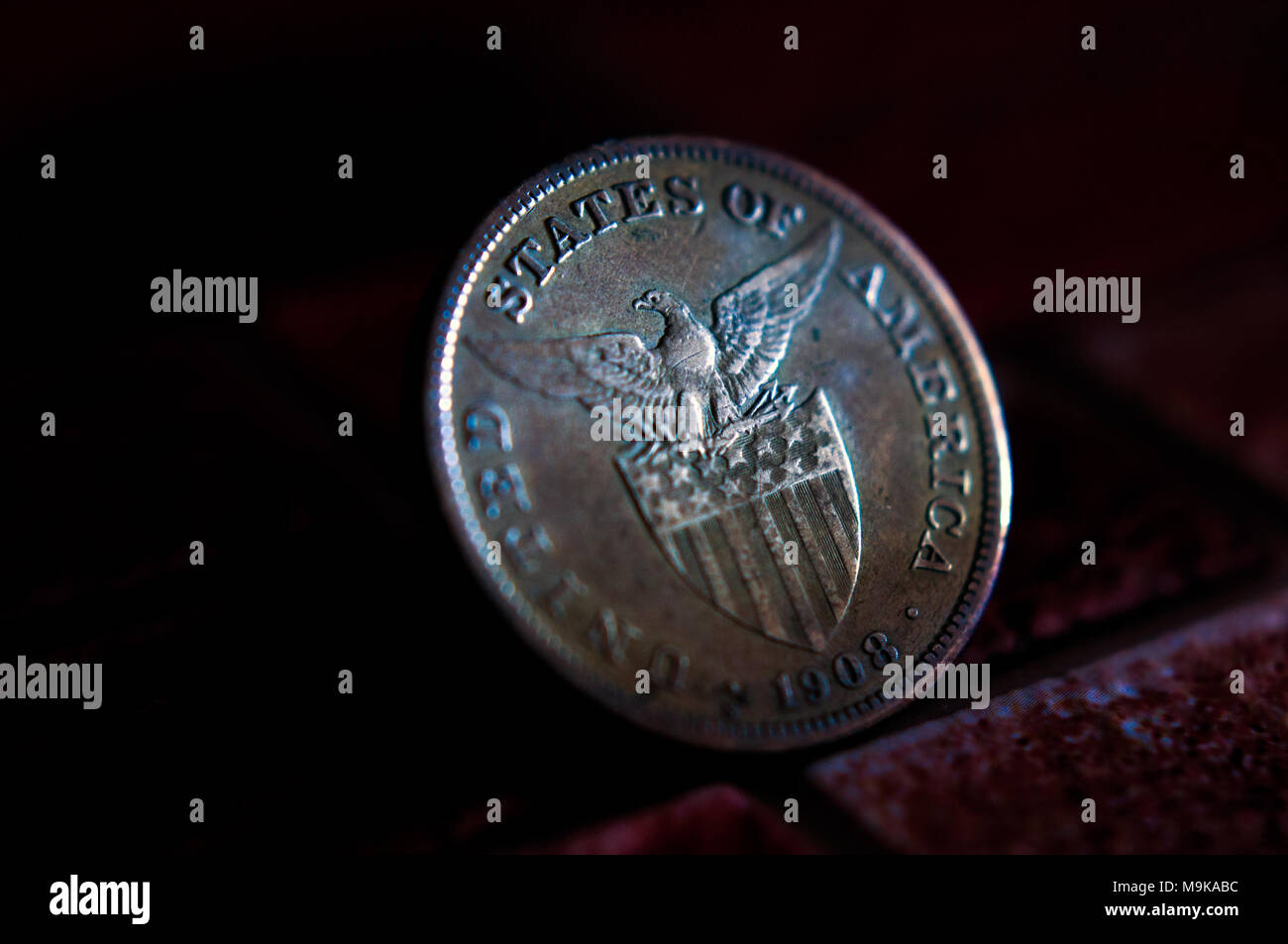 1908 Philippine pesos argento coniate monete sotto sovranità americana, e mostrando la American Eagle sopra a stelle e strisce scudo Foto Stock