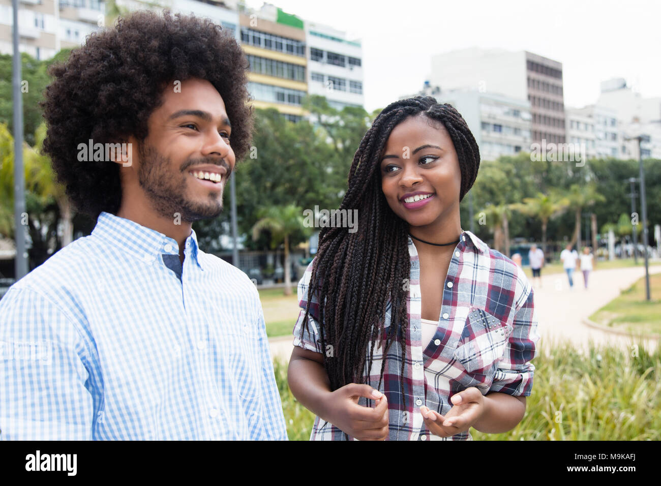 African American donna con dreadlocks flirtare con hipster uomo all'aperto nella città Foto Stock