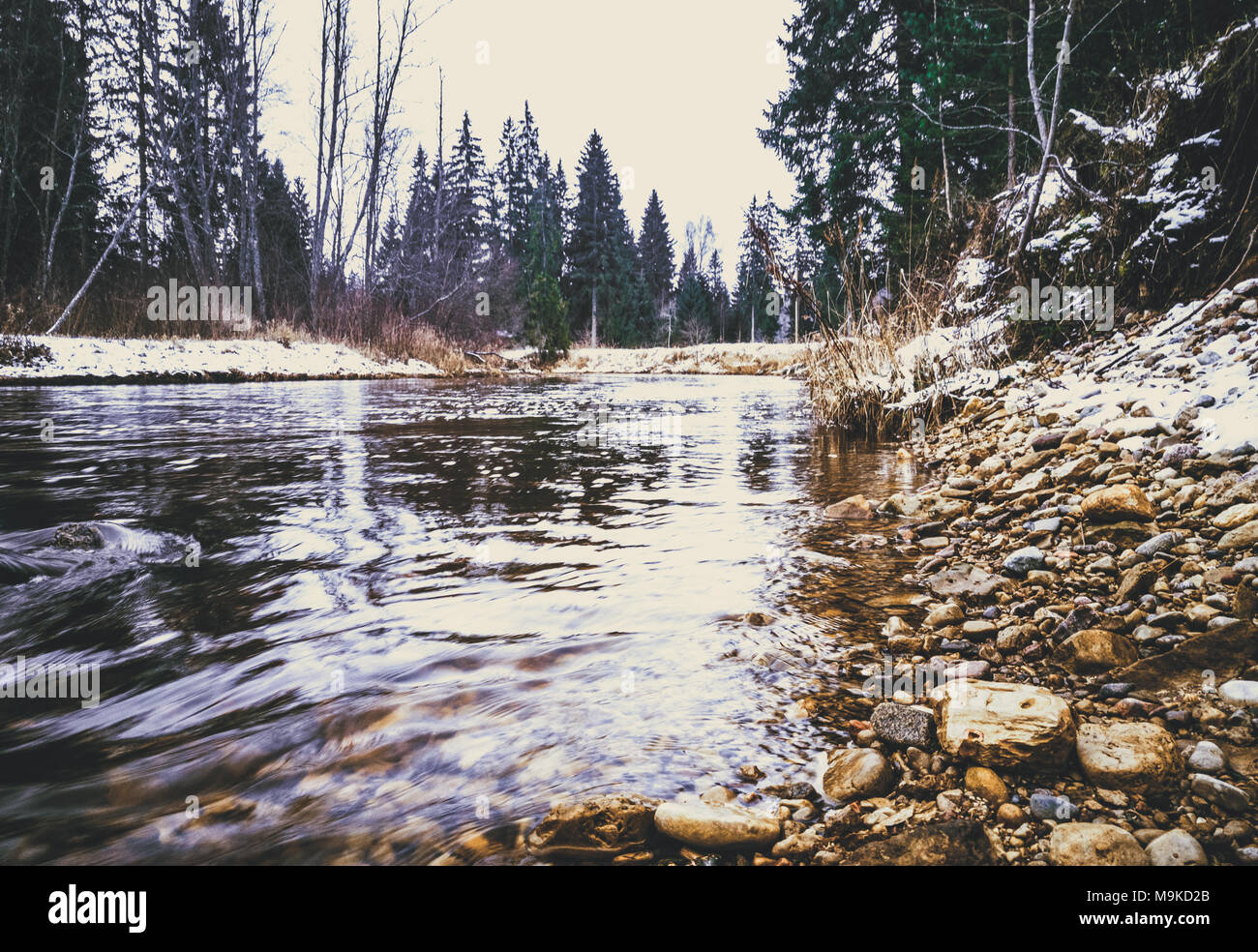 In prossimità del fiume in inverno con alcune pietre - look vintage modifica Foto Stock