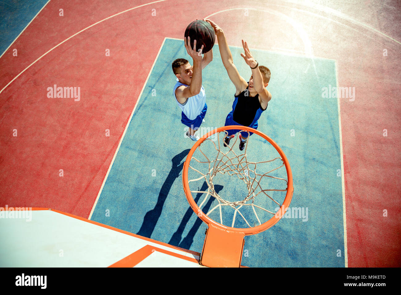 Angolo di alta vista del giocatore di basket dunking basket in hoop Foto Stock