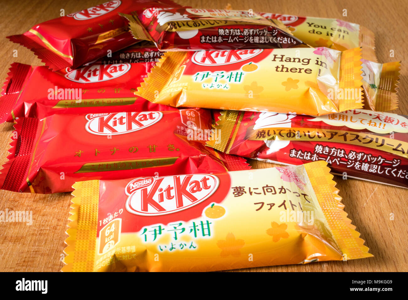 Assortimento di mini giapponese KitKat pacchetti su una superficie di legno. Arancia, fragola e gusto di gelato. Foto Stock