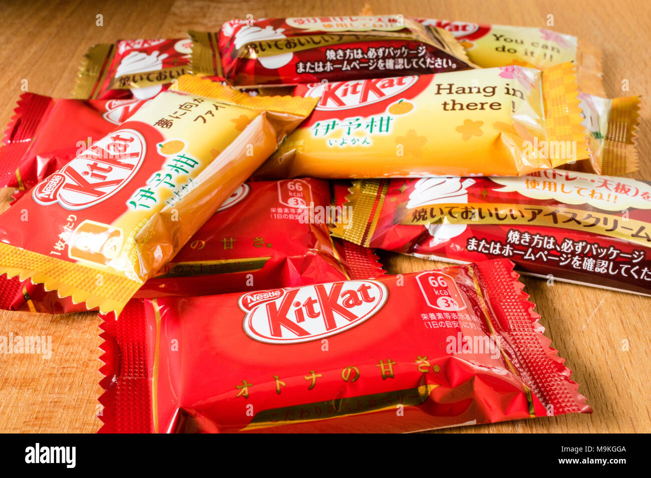 Assortimento di mini giapponese KitKat pacchetti su una superficie di legno. Arancia, fragola e gusto di gelato. Foto Stock