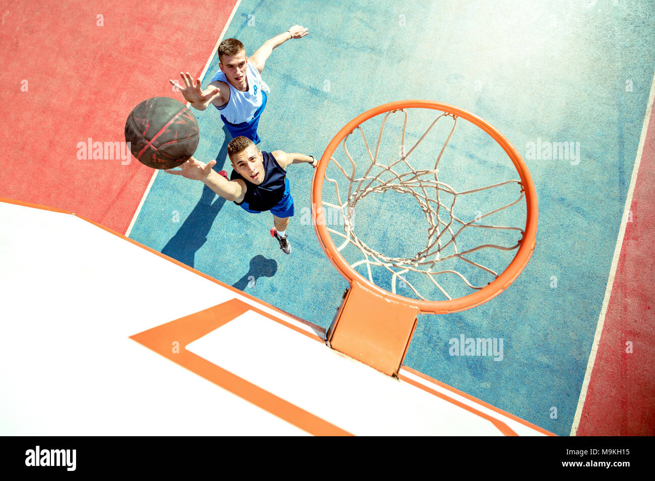 Angolo di alta vista del giocatore di basket dunking basket in hoop Foto Stock