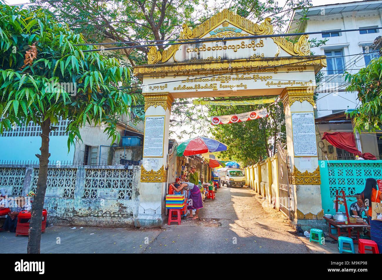 YANGON, MYANMAR - Febbraio 14, 2018: la porta Vecchia di Thayet Taw complesso buddista, decorata con iscrizioni in oro e modelli, Chinatown, su Febru Foto Stock