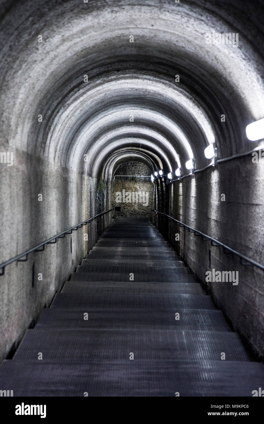 Arcuata di buio del tunnel illuminato con luci Foto Stock
