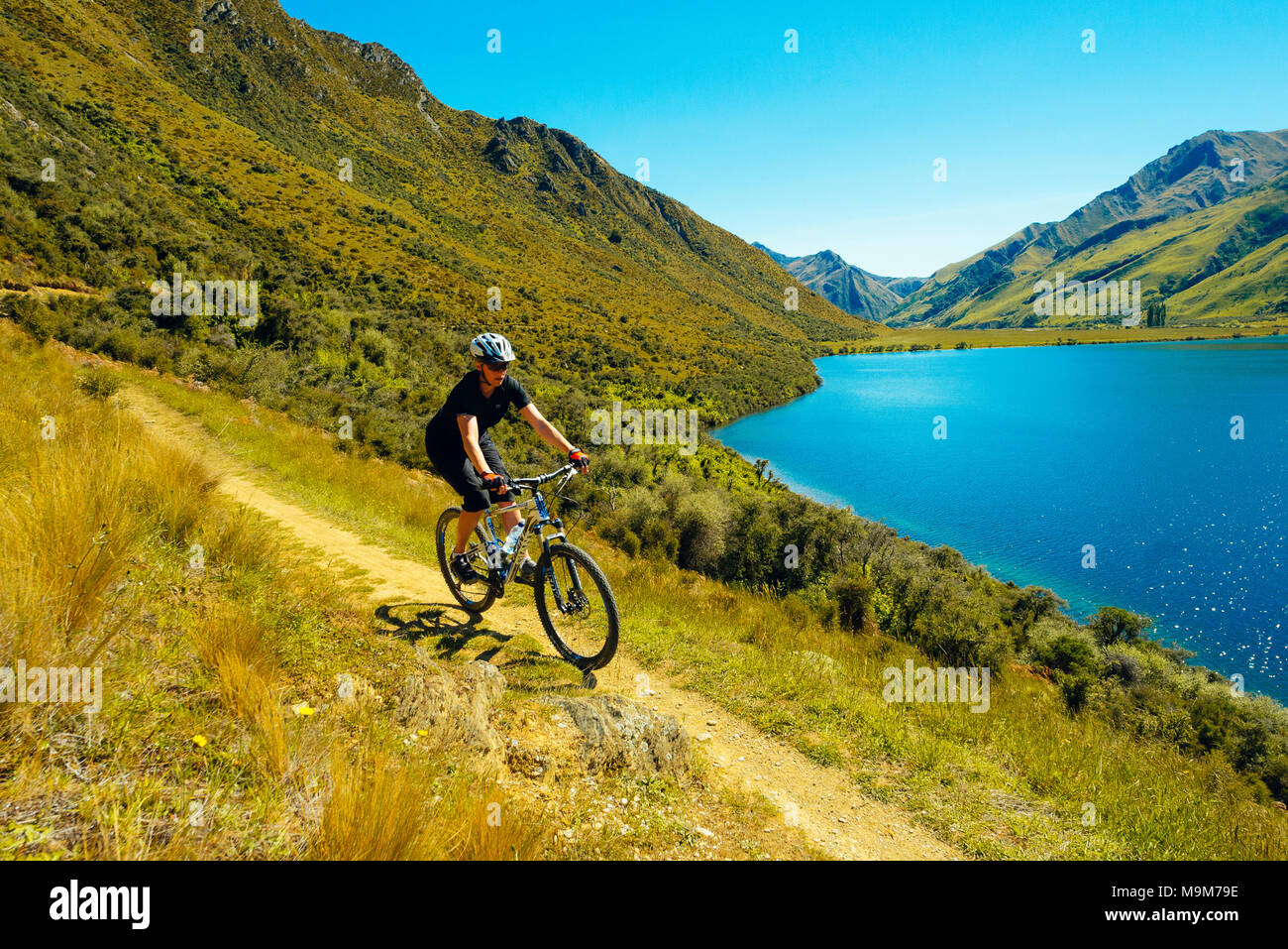 Mountain biker sulla fuma Lago Trail vicino a Queenstown, Nuova Zelanda Foto Stock
