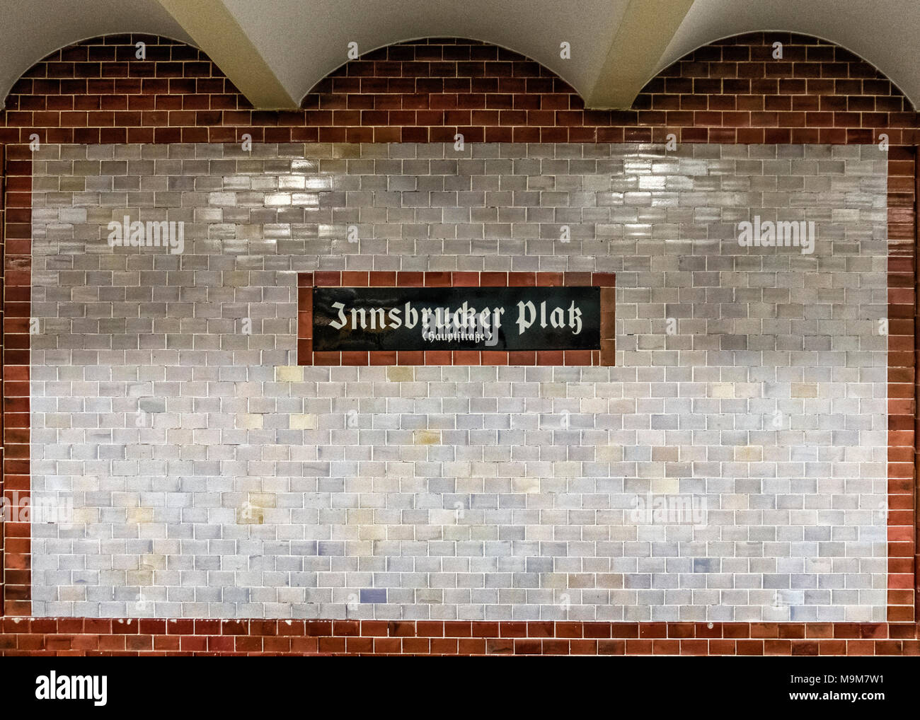 Berlin Schöneberg. Innsbrucker Platz della U-Bahn stazione ferroviaria interna, targhetta con il nome e rosso marrone e crema pareti piastrellate - progettato da Paolo Jatzow Foto Stock