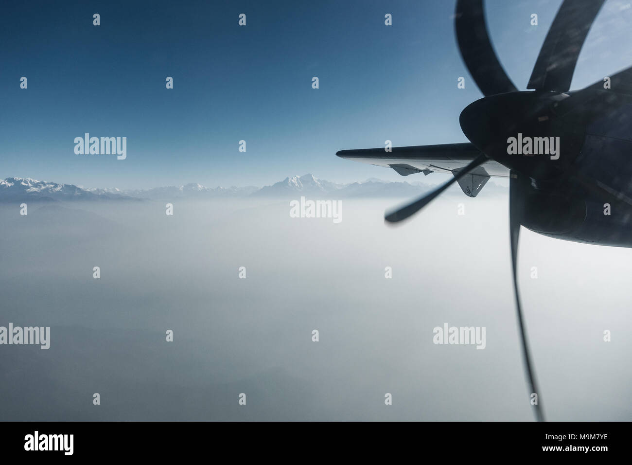 L'Himalaya come visto da un aereo ad elica in Nepal. Strato di nubi sotto le cime delle montagne. Foto Stock