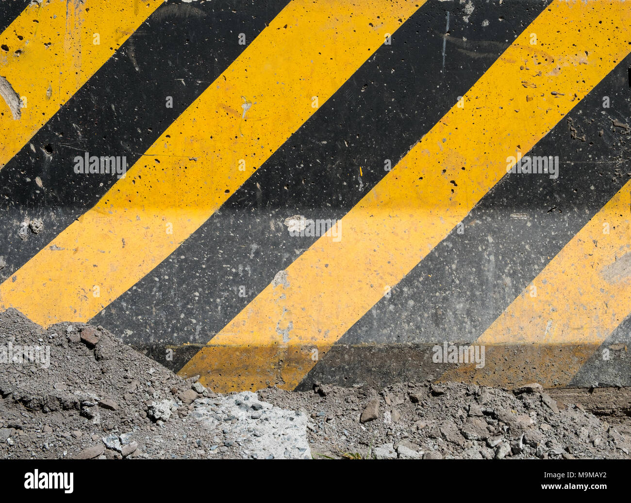 Nero e strisce gialle su una superficie in calcestruzzo, costruzione di sfondo del sito Foto Stock