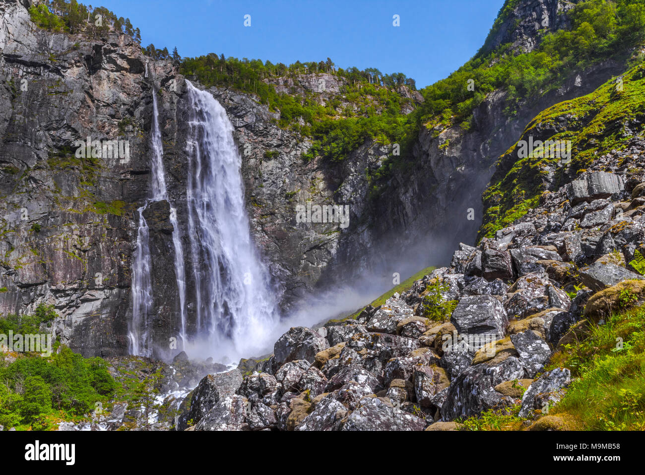 Cascata Feigumfossen con cliffy mountainscape, Norvegia, cascata con mucchio di pietre, presso il Lustrafjorden, Sognefjorden Foto Stock