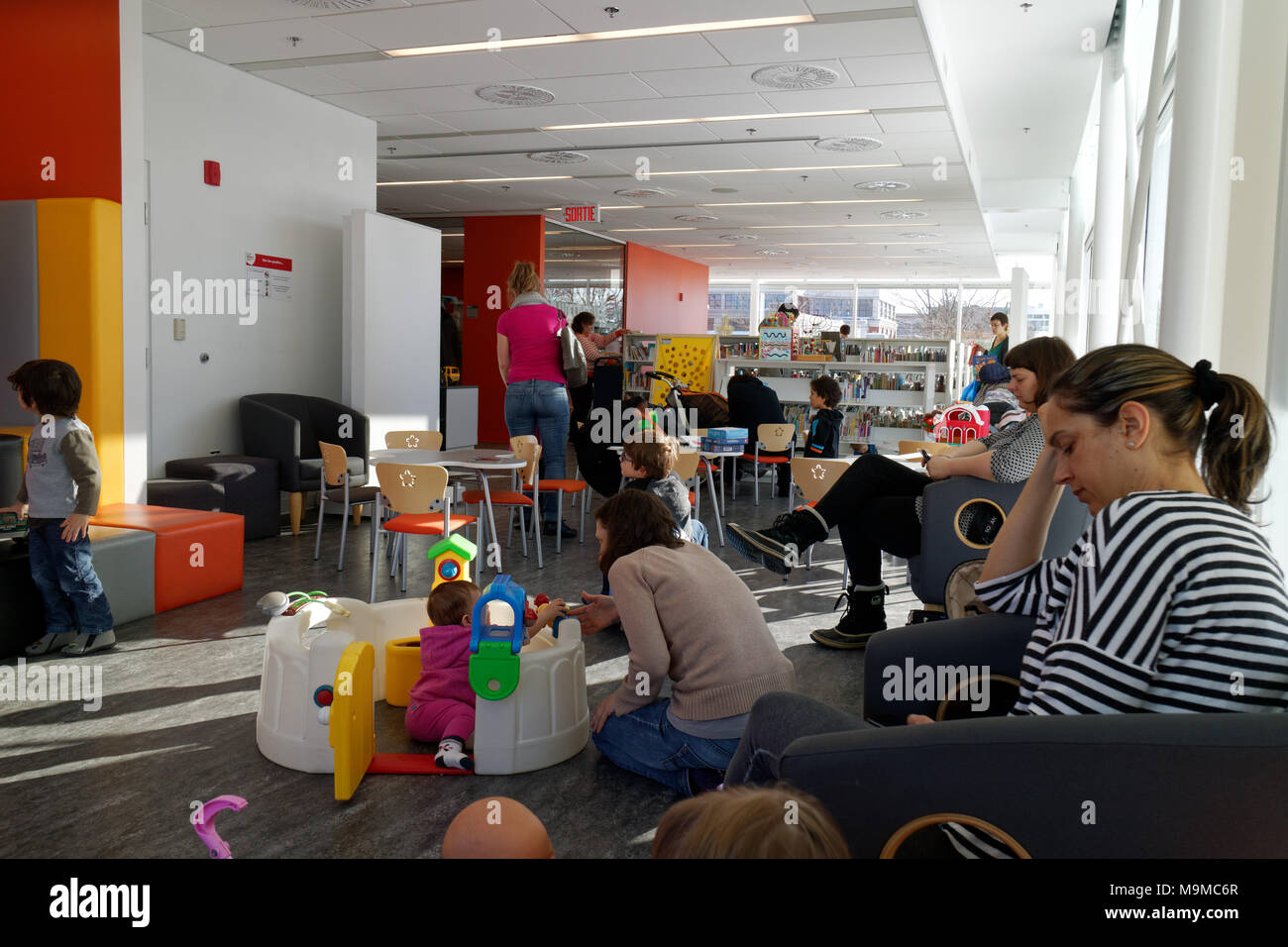 Le mamme con i loro bambini in un'area di gioco all'interno di una biblioteca pubblica nella città di Québec, Canada Foto Stock