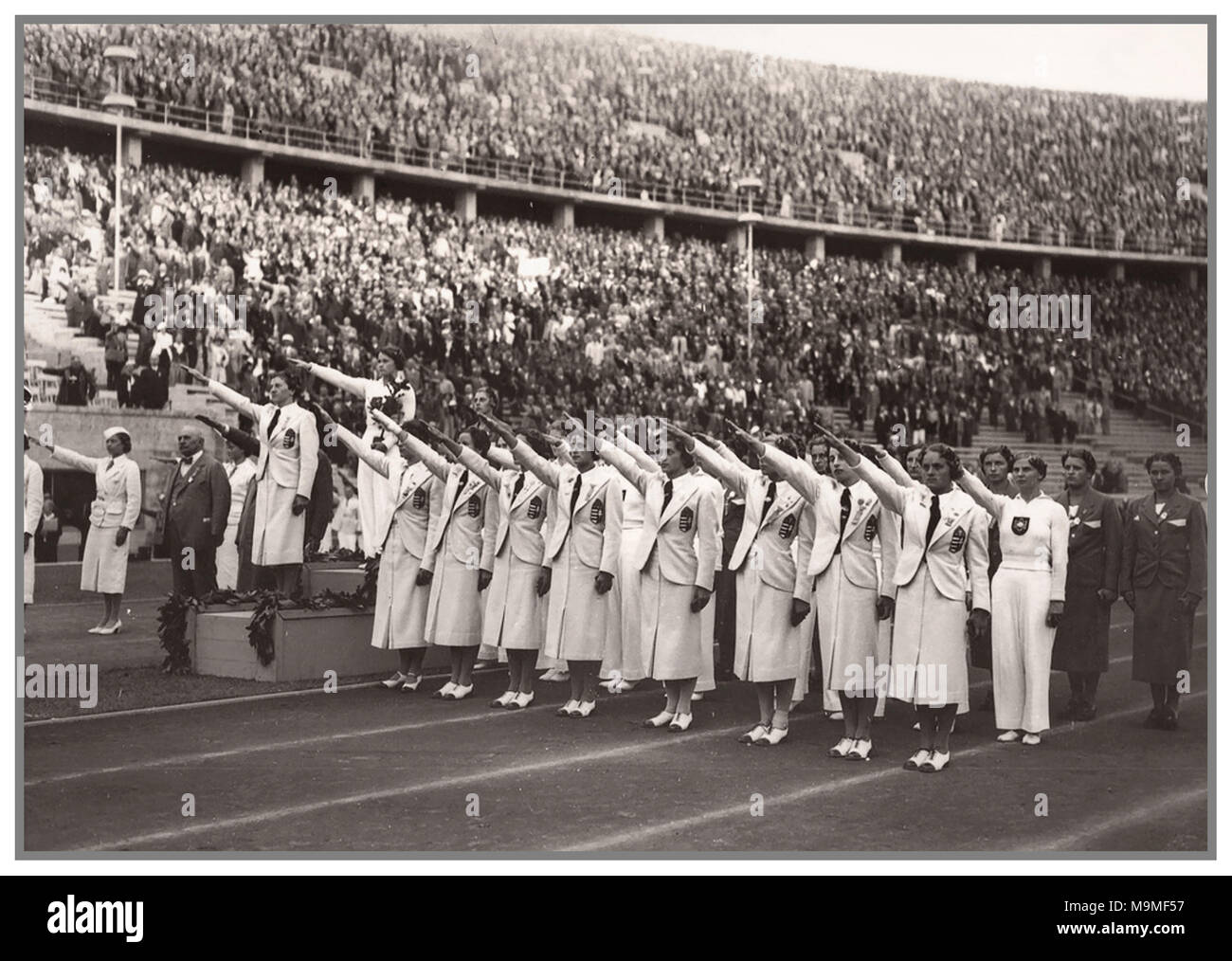 L'annata 1936 Olympics la medaglia di bronzo ungherese donna della squadra di ginnastica dando la necessaria Adolf Hitler salutate Seig Heil Foto Stock
