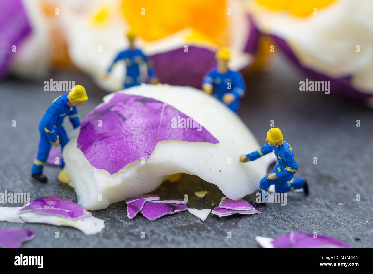 Lavoratore in miniatura le persone che lavorano sulle uova il concetto di pulizia Foto Stock