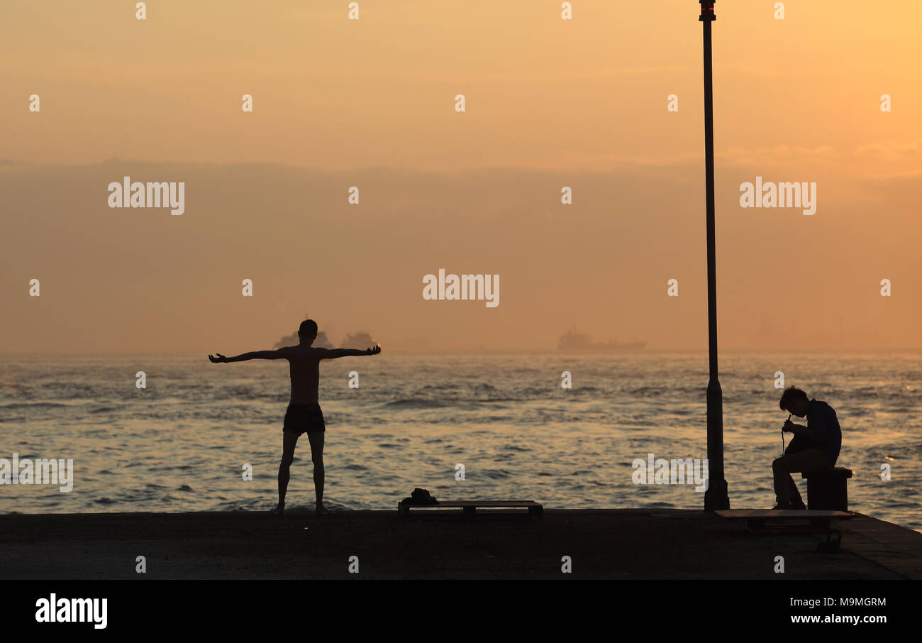 Uomo in piedi e urla al sole a hong kong, sheung wan. Foto Stock