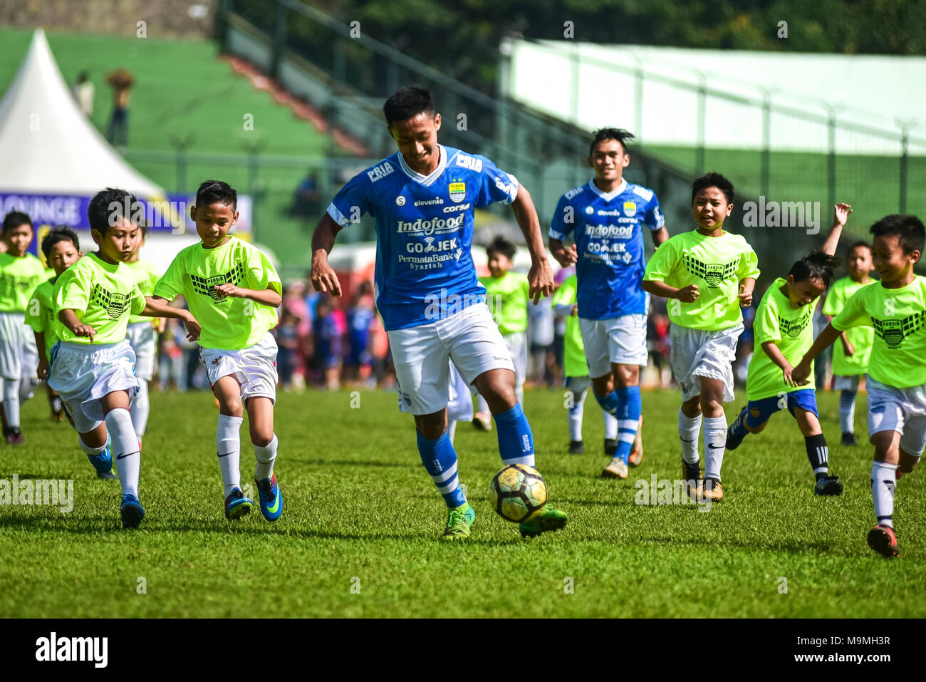Cinque giocatori di calcio indonesiano club di Persib Bandung giocare contro 85 bambini in un match di esibizione per festeggiare il suo ottantacinquesimo anniversario. Foto Stock
