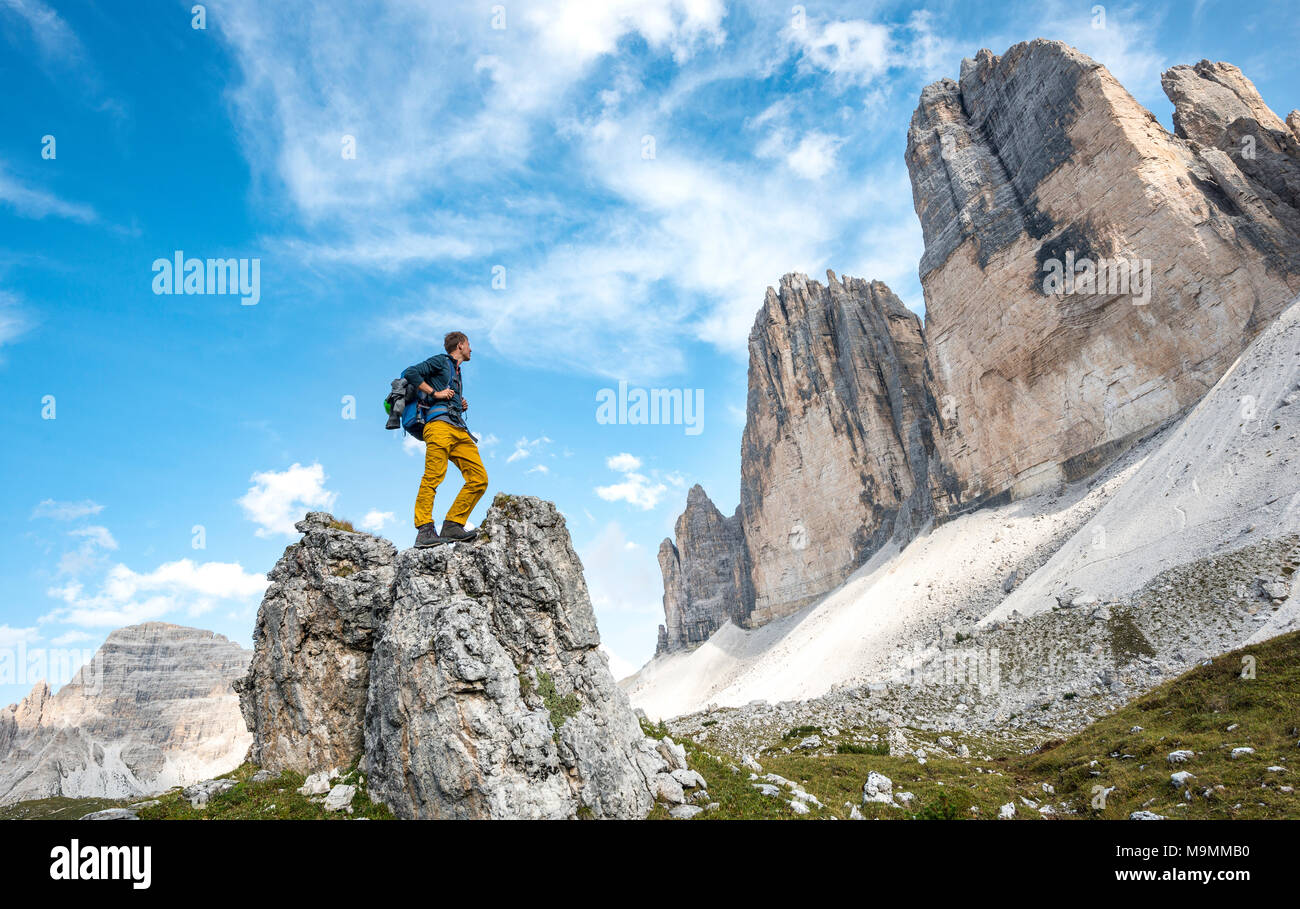 Escursionista si erge sulla roccia, pareti nord delle Tre Cime di Lavaredo, Sesto Dolomiti Alto Adige, Trentino Alto Adige Foto Stock