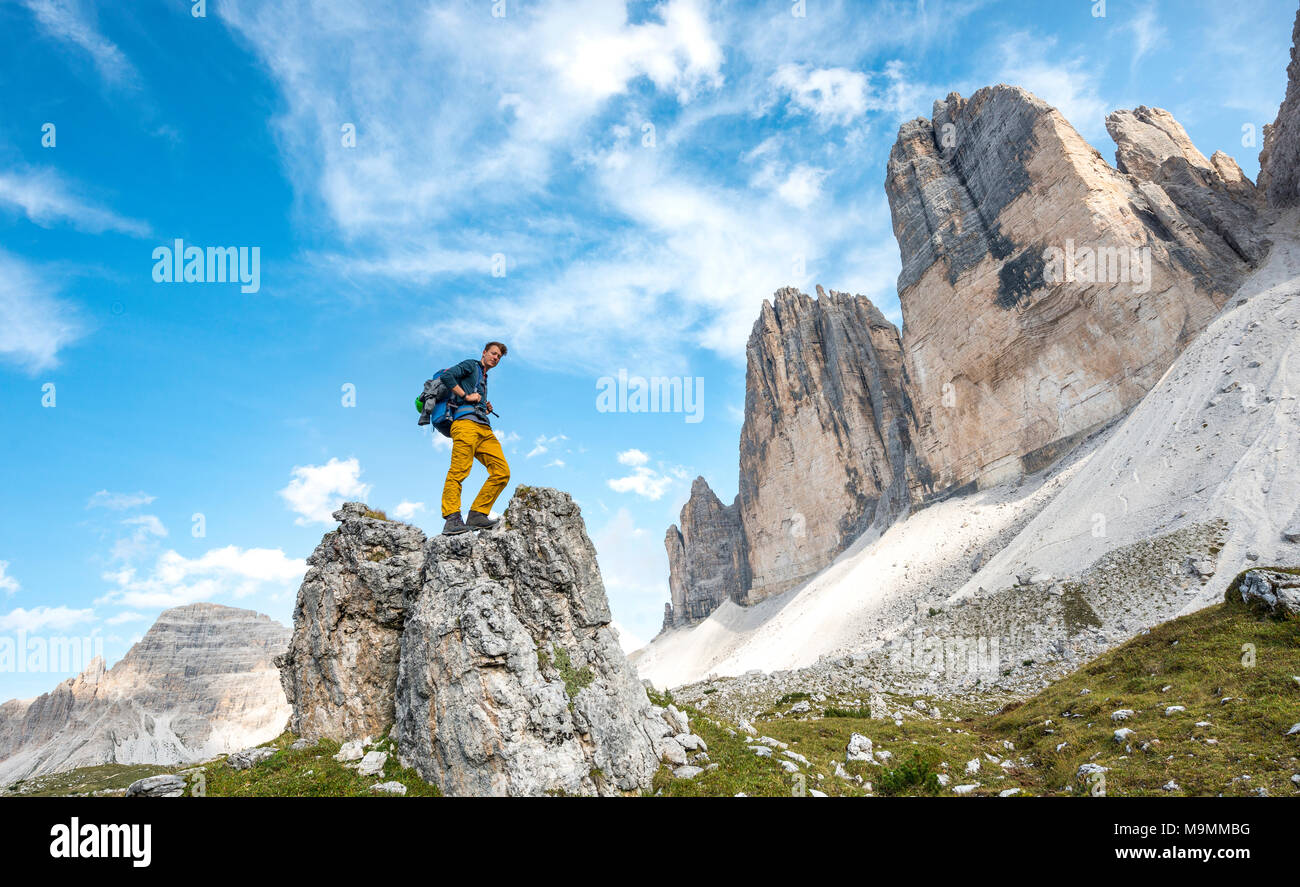 Escursionista si erge sulla roccia, pareti nord delle Tre Cime di Lavaredo, Sesto Dolomiti Alto Adige, Trentino Alto Adige Foto Stock