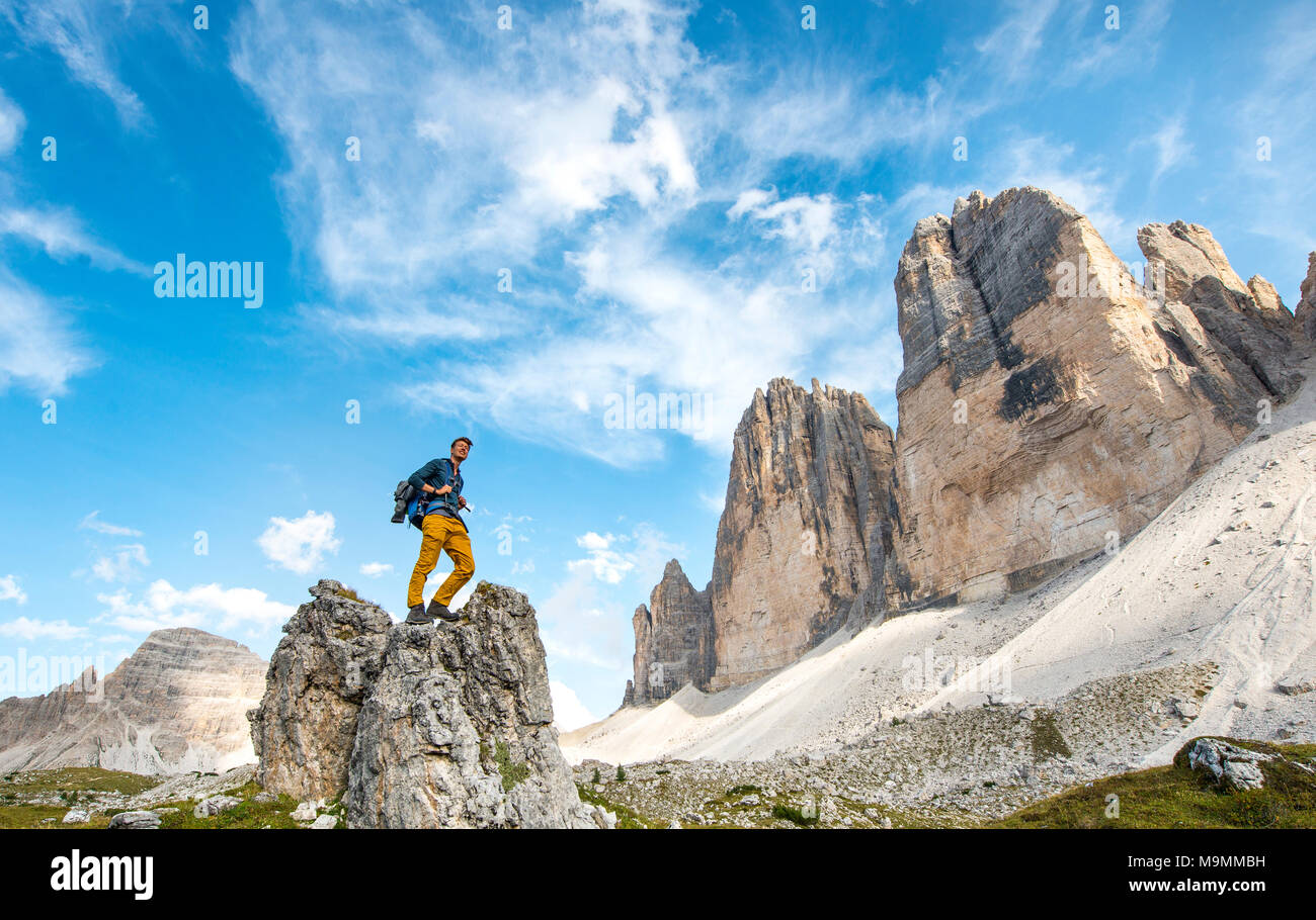 Escursionista si erge sulla roccia, pareti nord delle Tre Cime di Lavaredo, Sesto Dolomiti Alto Adige, Trentino Alto Adige Foto Stock
