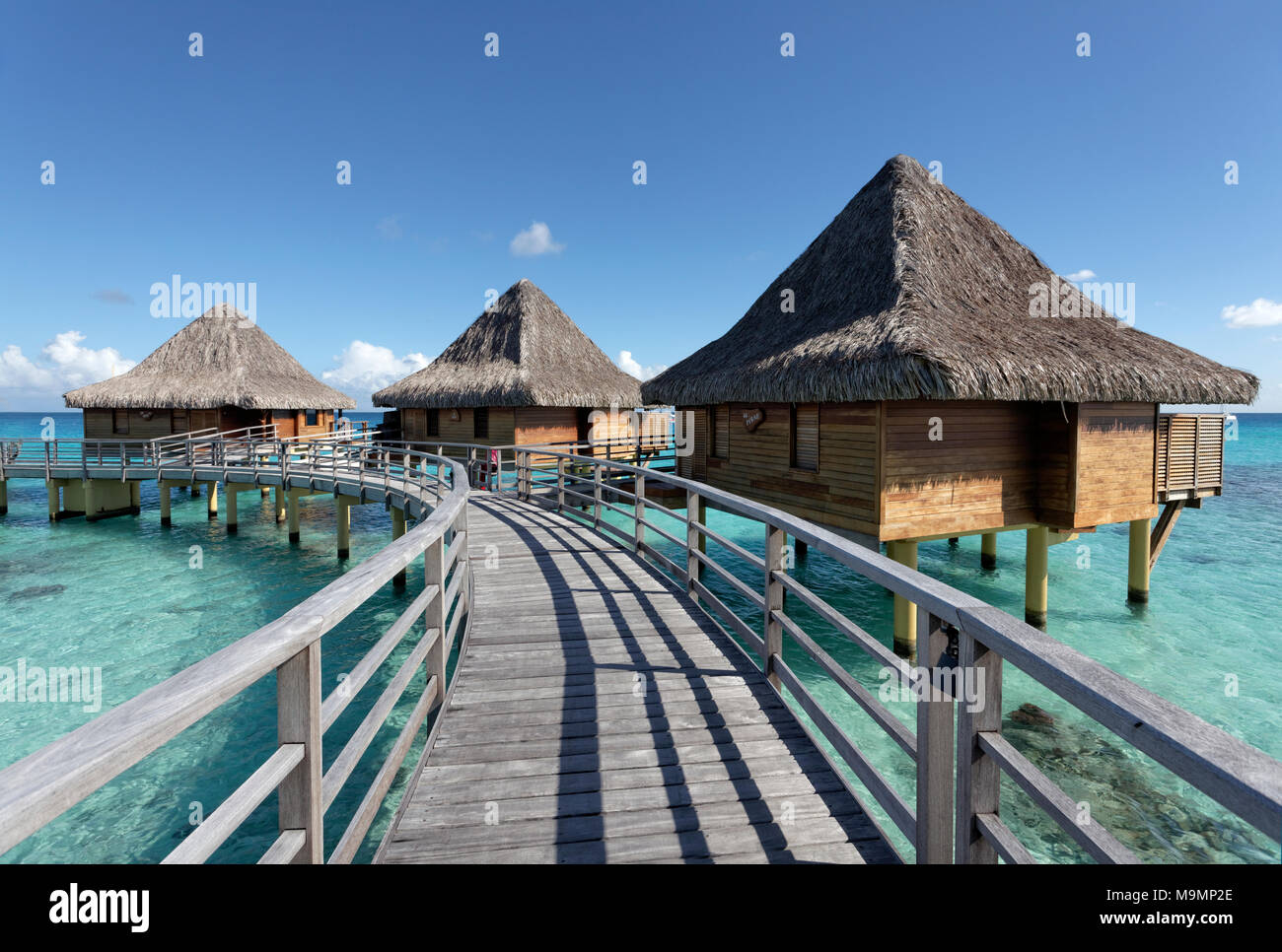 Bungalows, acqua bungalows con pier nel mare oceano Pacifico, KiaOra Hotel Resort & Spa, Rangiroa, Isole della Società Foto Stock