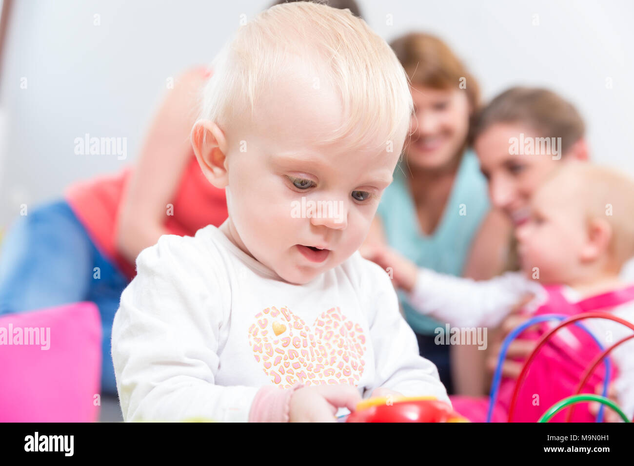 Ritratto di un simpatico bionda bambina gioca con i giocattoli colorati Foto Stock