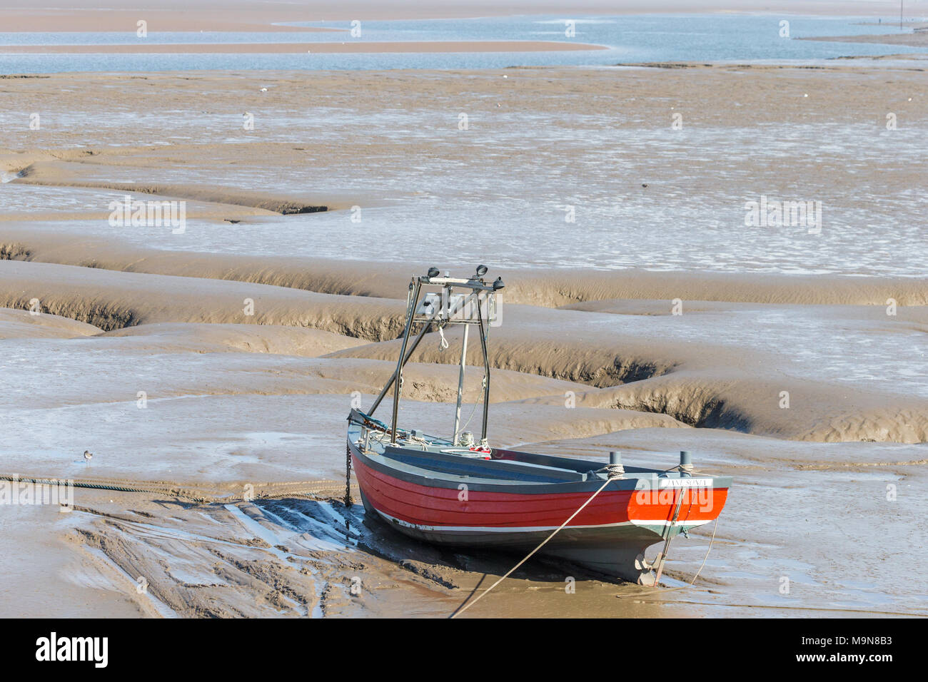 Una piccola pesca costiera arenarsi in barca e in attesa che la marea a Morecambe, England, Regno Unito Foto Stock