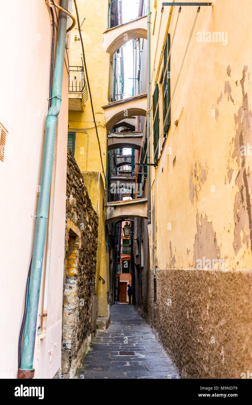 Stretto vicolo buio in un italiano medievale città tradizionale con pareti a spiovente e contrafforti tra gli edifici Foto Stock