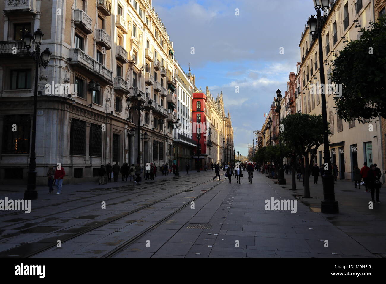 Avenida de la Constitucion, Main Street a Siviglia, in Andalusia, la Spagna, la luce del tramonto su edifici Foto Stock