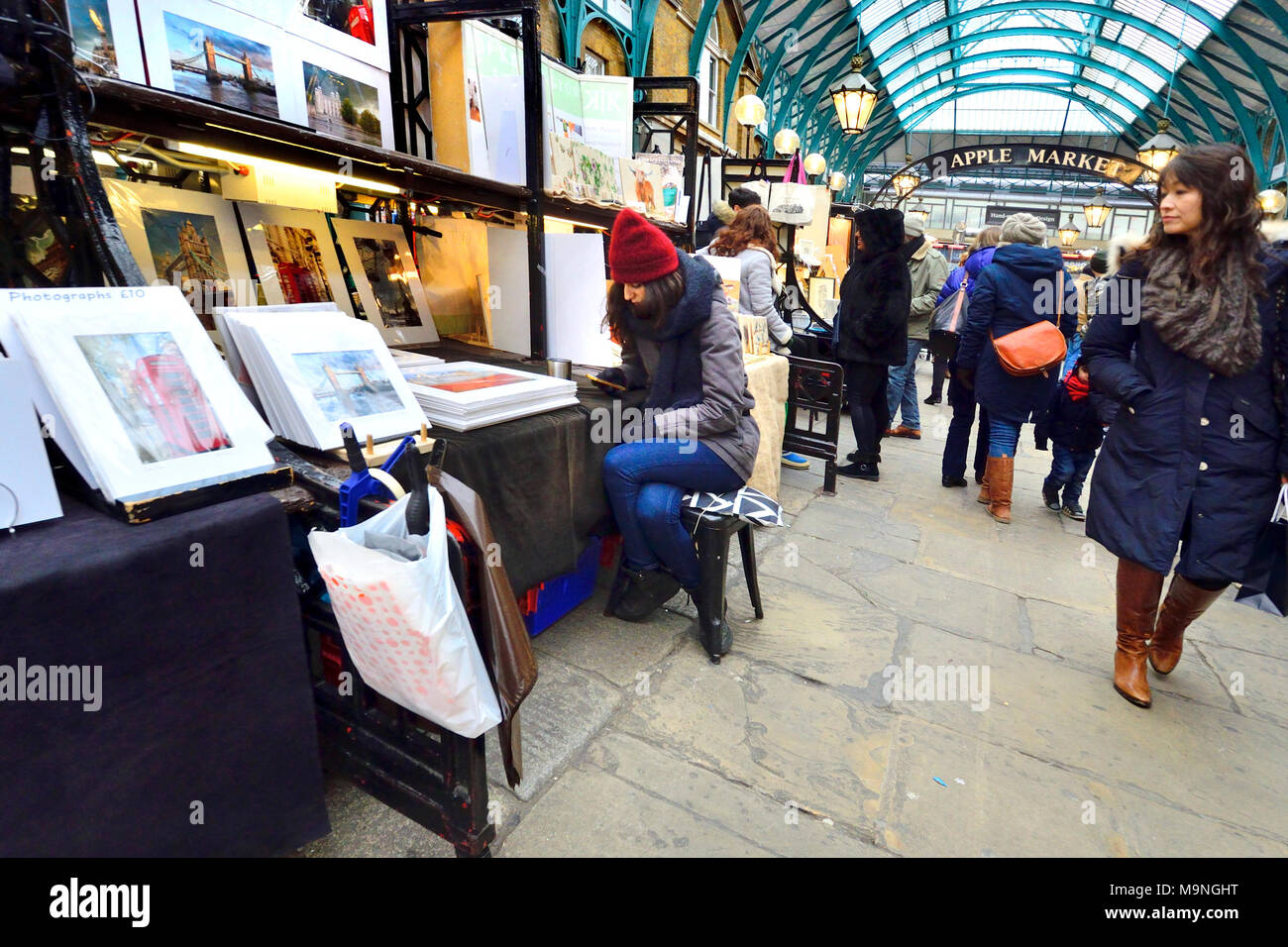 Londra, Inghilterra, Regno Unito. Stallholder nel mercato di Covent Garden, sul suo telefono cellulare Foto Stock