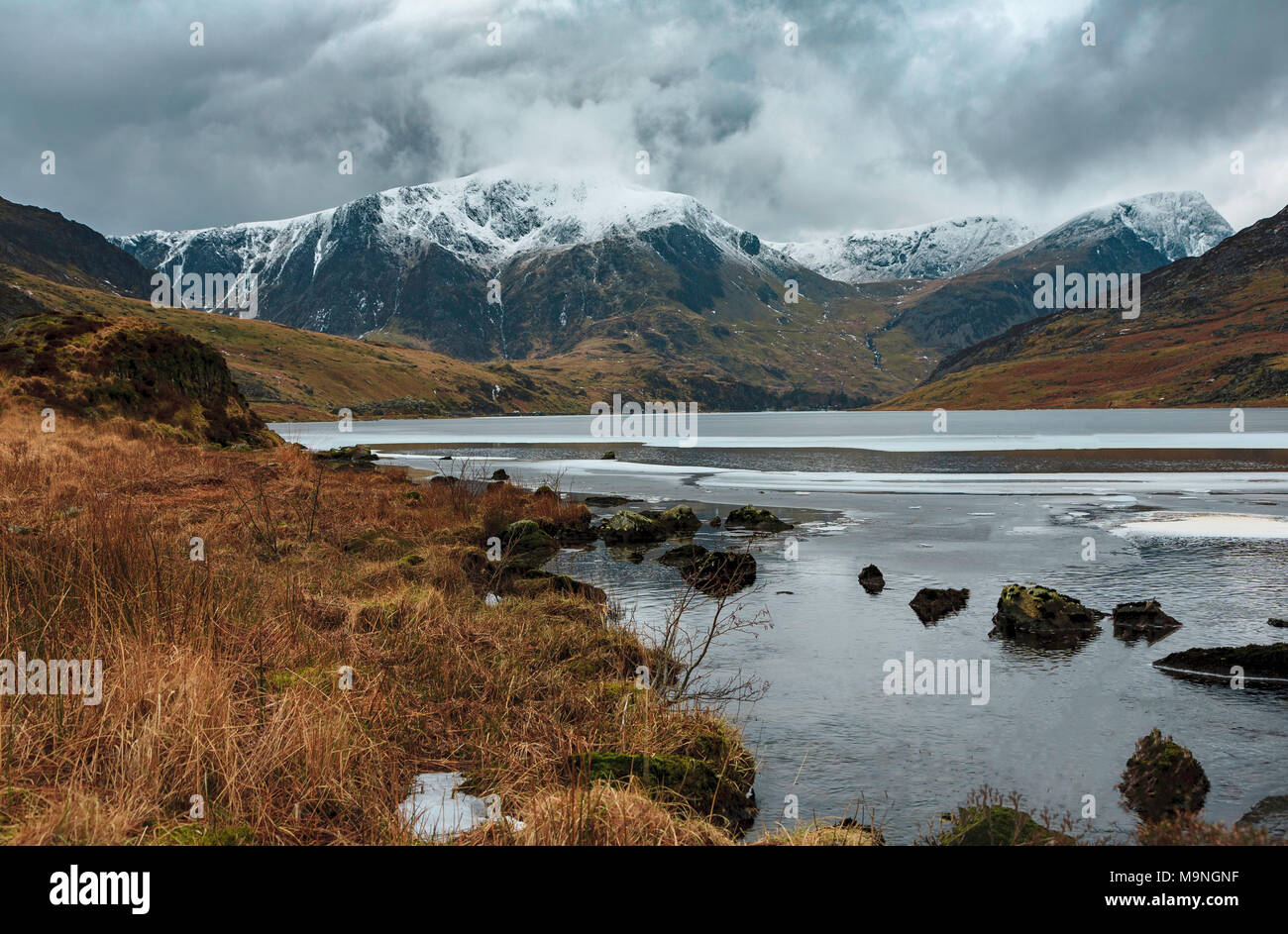 Un gelido Llyn Ogwen con un Snow capped monte Tryfan verso la parte posteriore. Foto Stock