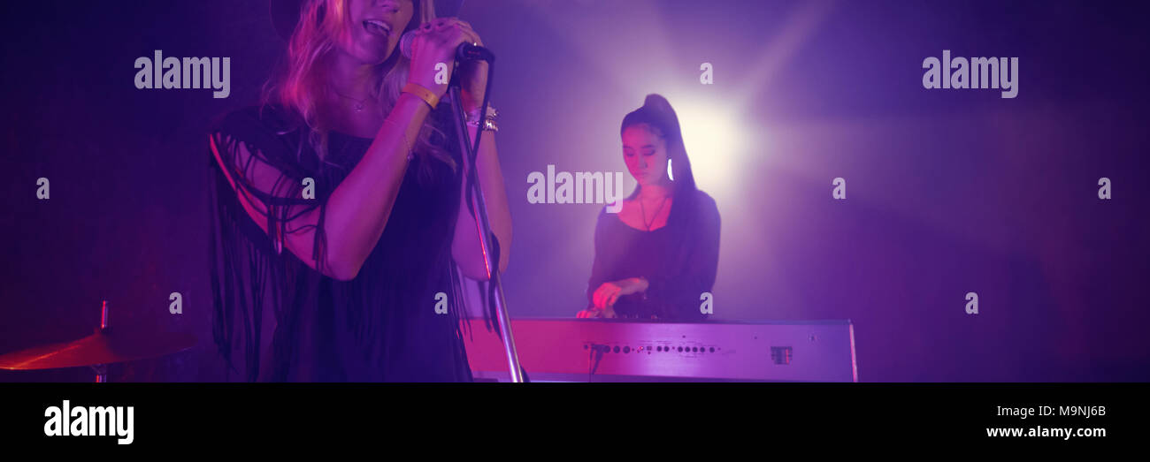 Il cantante cantare mentre musicista suonare il pianoforte in discoteca Foto Stock