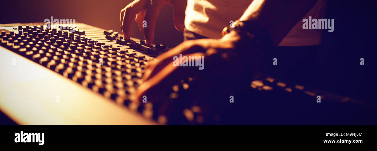 Funzionamento DJ Mixer audio in discoteca illuminata Foto Stock