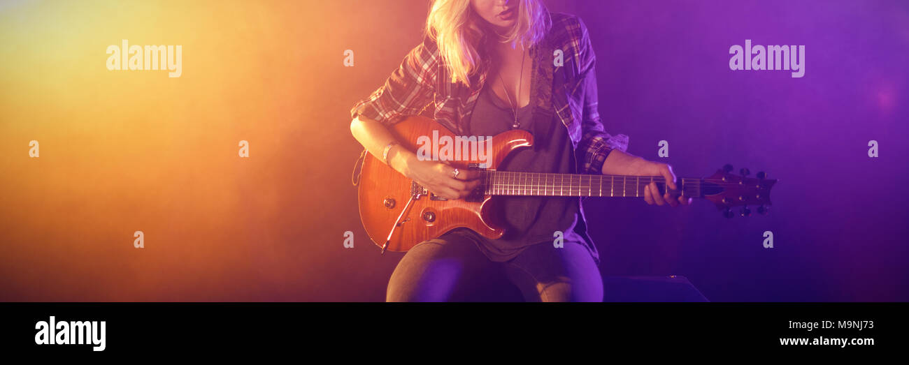 Chitarrista femmina eseguendo in discoteca Foto Stock
