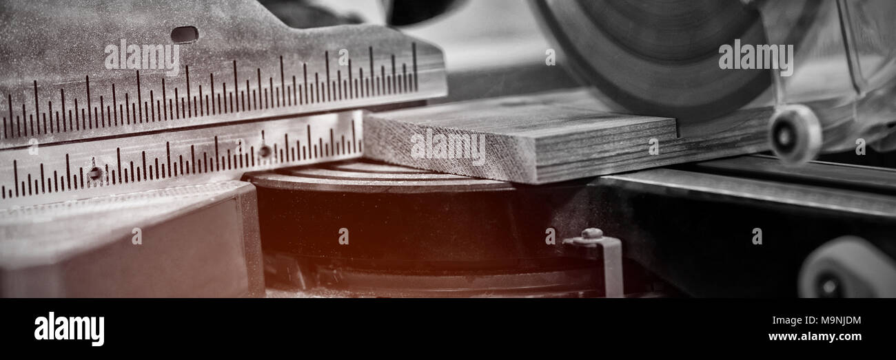 Mola della macchina di taglio il taglio di un pezzo di legno Foto Stock