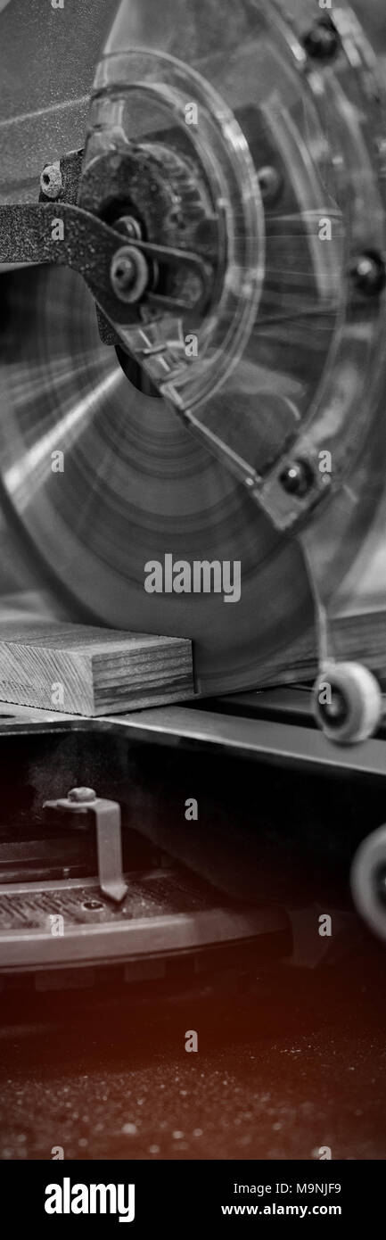 Mola della macchina di taglio il taglio di un pezzo di legno Foto Stock